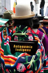 A Bolivian indigenous woman carrying an indigenous autonomy document on her back attends a ceremony in Camiri
